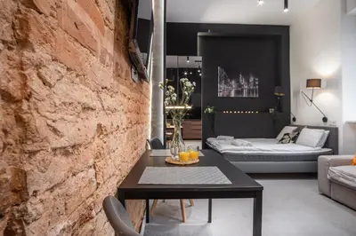 a living room with a brick wall and a table at Apartments Floriańska 24 by MB Apartments in Kraków