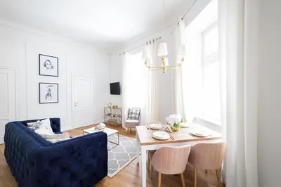 a living room with a blue couch and a table at Apartament Golden Place in Kraków