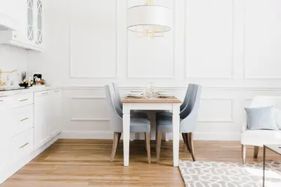 a dining room table with blue chairs and a chandelier at Apartament Golden Place in Kraków