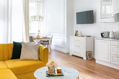 a living room with a yellow couch and a table at Apartament Golden Place in Kraków