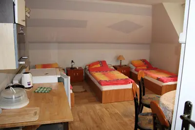 a small room with two beds and a table at Podelniska in Porąbka