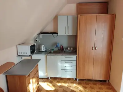 a small kitchen with white cabinets and a sink at Podelniska in Porąbka