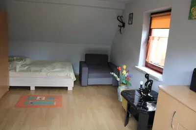 a small bedroom with a bed and a chair at Podelniska in Porąbka