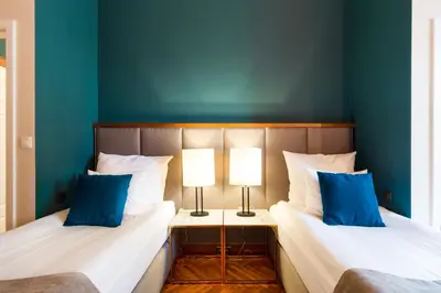 two beds in a room with blue walls at MR 3 Apartments in Kraków