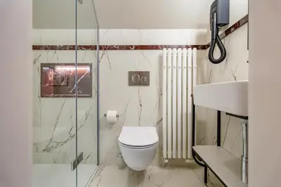 a bathroom with a toilet and a glass shower at MR 3 Apartments in Kraków