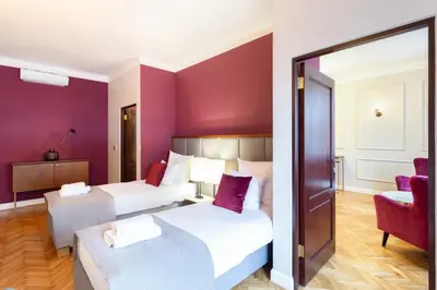 a hotel room with two beds and a chair at MR 3 Apartments in Kraków