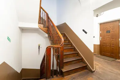 a staircase in a building with a wooden door at MR 3 Apartments in Kraków