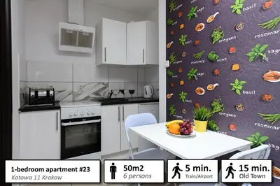 a kitchen with a table and a wall with fruits and vegetables at Station Apartments Katowa 11 in Kraków
