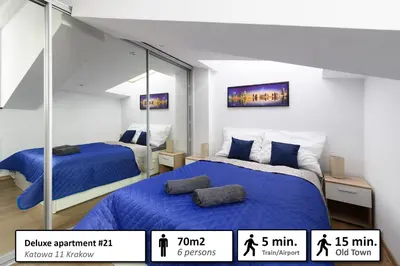a bedroom with two beds and a mirror at Station Apartments Katowa 11 in Kraków