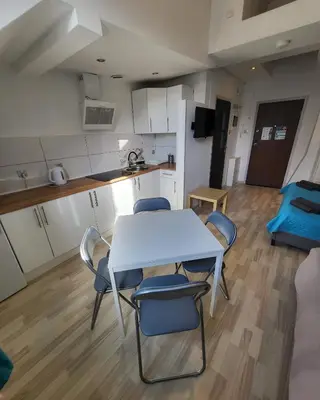 a kitchen and a table and chairs in a room at Station Apartments Katowa 11 in Kraków