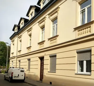 a white van parked in front of a building at Station Apartments Katowa 11 in Kraków