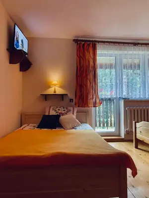a bedroom with a large bed and a window at Agroturystyka SKALNE in Szczawa