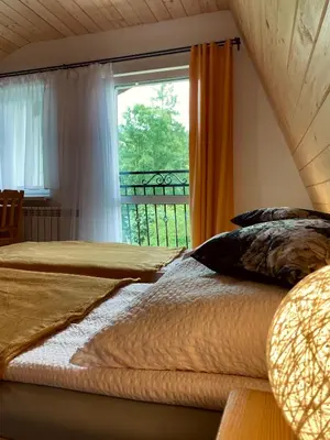 a bedroom with two beds and a window at Agroturystyka SKALNE in Szczawa