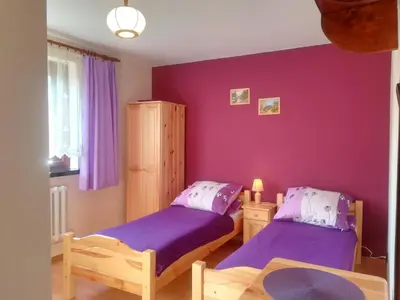 two beds in a room with purple walls at Agroturystyka SKALNE in Szczawa