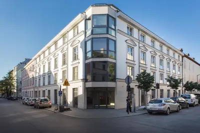 a large white building with cars parked in front of it at City Point Apartment Old Jewish Quarter in Kraków