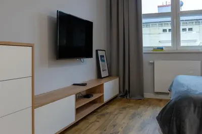 a bedroom with a flat screen tv on a wall at Native Apartments Augustiańska 24 in Kraków