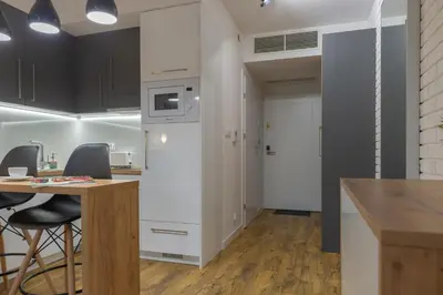 an open kitchen and dining room with a table and chairs at Native Apartments Augustiańska 24 in Kraków