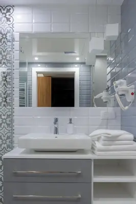 a white bathroom with a sink and a mirror at Native Apartments Augustiańska 24 in Kraków