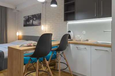 a kitchen with two chairs and a table in a room at Native Apartments Augustiańska 24 in Kraków