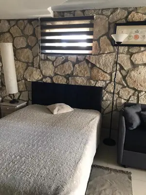 a bedroom with a bed and a stone wall at Studio Roxi in Bachowice