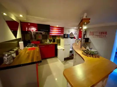 a small kitchen with red cabinets and a counter top at Studio Roxi in Bachowice