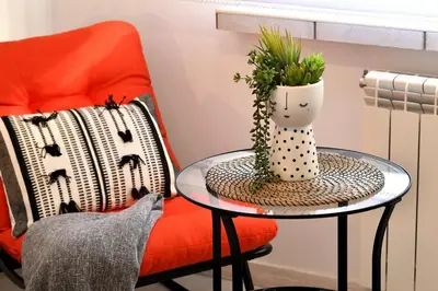 a table with a chair and a vase with a plant at Apartament Spytkowice - ENERGYLANDIA KRAKÓW OŚWIĘCIM WADOWICE in Spytkowice