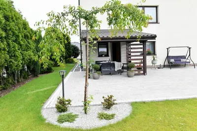 a patio with a tree in the middle of a yard at Apartament Spytkowice - ENERGYLANDIA KRAKÓW OŚWIĘCIM WADOWICE in Spytkowice