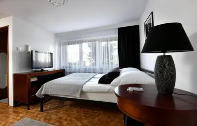 a bedroom with a bed and a table with a lamp at Apartament Spytkowice - ENERGYLANDIA KRAKÓW OŚWIĘCIM WADOWICE in Spytkowice