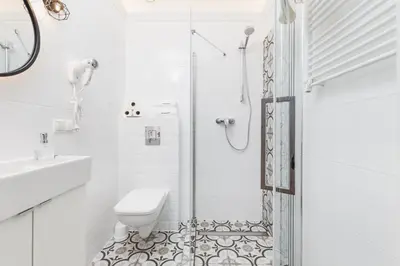 a white bathroom with a shower and a toilet at The Old Town View in Kraków