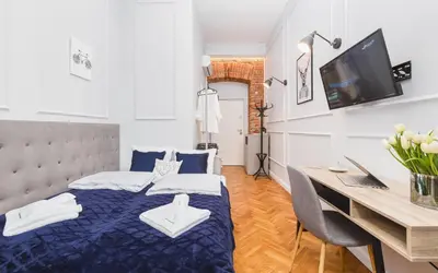 a bedroom with a bed and a desk with a computer at The Old Town View in Kraków