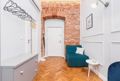 a living room with a blue chair and a brick wall at The Old Town View in Kraków