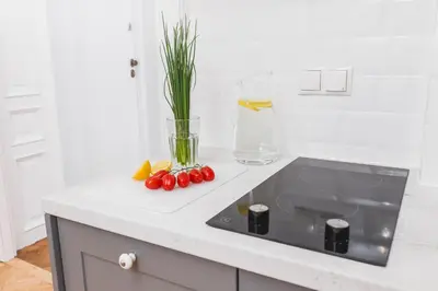 a kitchen counter with a sink and fruit on it at The Old Town View in Kraków