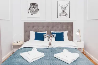 a bedroom with a bed with blue and white pillows at The Old Town View in Kraków