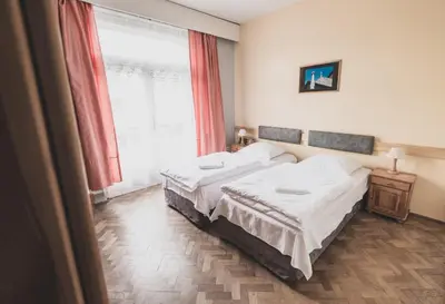 a bedroom with two beds and a large window at Cybulskiego Guest Rooms in Kraków