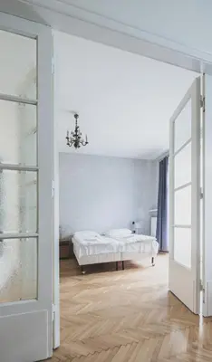 a white bedroom with a bed and a window at Cybulskiego Guest Rooms in Kraków