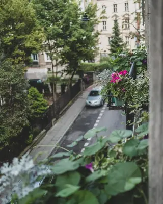 a car parked on a street with flowers in a balcony at Cybulskiego Guest Rooms in Kraków