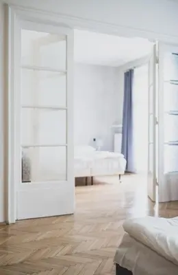 a white room with a bed and a mirror at Cybulskiego Guest Rooms in Kraków