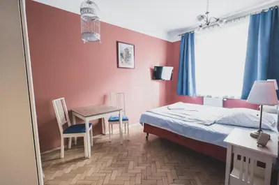 a bedroom with a bed and a table and chairs at Cybulskiego Guest Rooms in Kraków