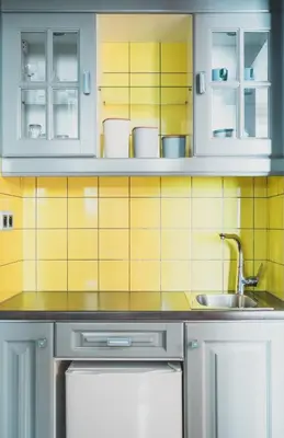 a kitchen with white cabinets and a sink at Cybulskiego Guest Rooms in Kraków