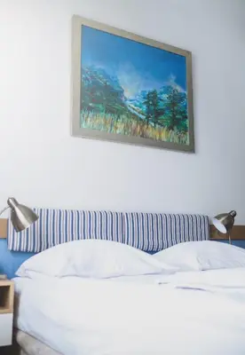 a bedroom with a bed with a picture on the wall at Cybulskiego Guest Rooms in Kraków