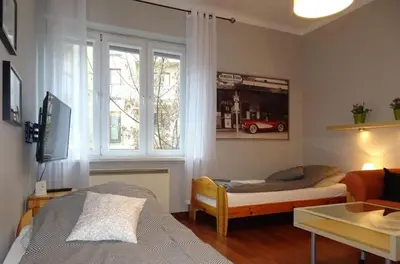 a living room with a bed and a window at Cybulskiego Guest Rooms in Kraków