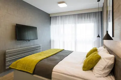 a bedroom with a bed with a television on the wall at Exclusive Apartment Solna 1 in Kraków