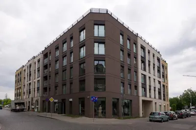 a brown building on a street with cars parked in front at Exclusive Apartment Solna 1 in Kraków
