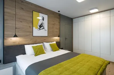 a bedroom with a large bed with a yellow blanket at Exclusive Apartment Solna 1 in Kraków