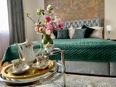 a living room with a green bed with a vase of flowers at Dom Gościnny Krystyna - ENERGYLANDIA, SPYTKOWICE, ZATOR in Spytkowice