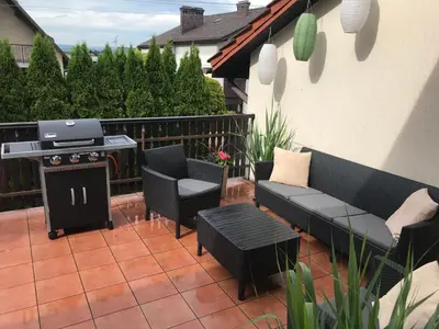 a patio with a grill and a couch and chairs at Dom Gościnny Krystyna - ENERGYLANDIA, SPYTKOWICE, ZATOR in Spytkowice