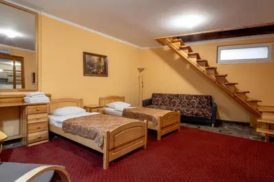 a room with two beds and a staircase at Pensjonat Stańczyk in Kraków