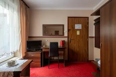 a room with a desk with a chair and a door at Pensjonat Stańczyk in Kraków
