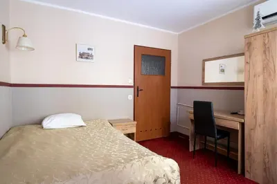a hotel room with a bed and a desk and a desk at Pensjonat Stańczyk in Kraków