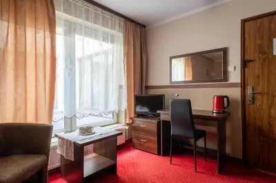 a hotel room with a desk and a window at Pensjonat Stańczyk in Kraków